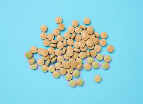 Yellow round pill for healthcare. Medical treatment, blue background, top view photo