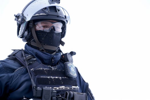 A snow-covered law enforcement officer stands vigilant in wintry weather conditions photo