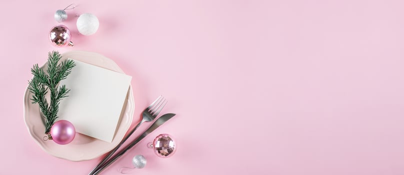 Pink plate with silver cutlery on pink background. Christmas background with decoration photo