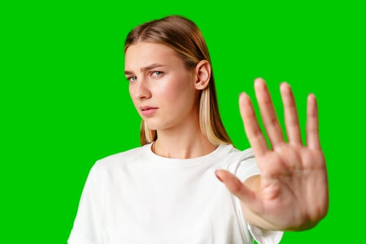 Young Woman Making Stop Sign Gesture on green background photo