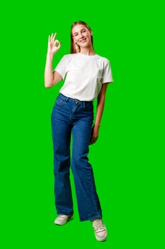 Young Woman Giving Thumbs Up Sign on Green Screen photo