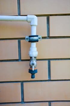 Garden outdoor tap. Gardening faucet for watering on the brick wall. photo