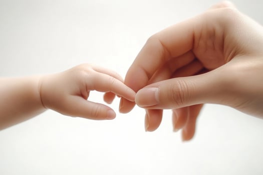 Close-up of a child's hand holding a mother's finger photo