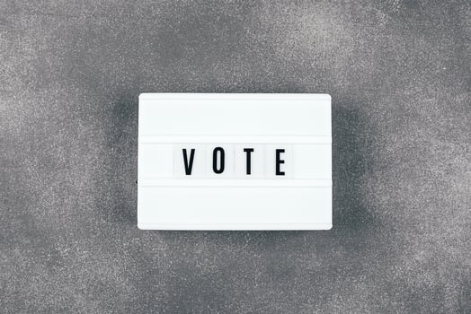 The word VOTE written on lightbox on background. Election concept photo