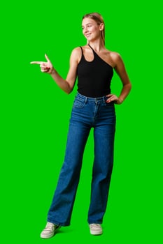 Young Woman Pointing at Something against green background photo