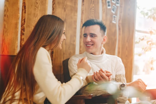 Young Couple Enjoying A Lighthearted Conversation At A Cozy Cafe During The Day photo