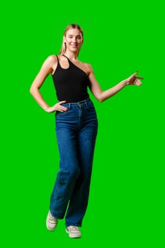 Young Woman Pointing at Something against green background photo