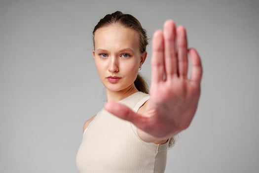 Young Woman Making Stop Sign With Hands on gray background photo
