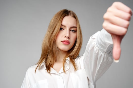 Young Woman in White Shirt Pointing Finger Down Dislike photo
