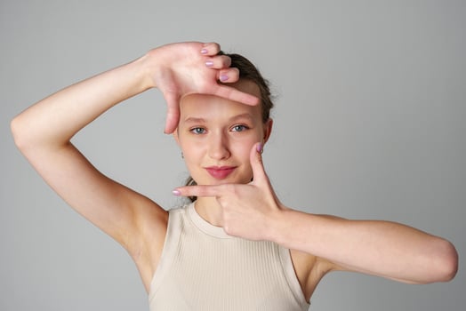 Woman Posing for Picture With Hands on Head on gray background photo