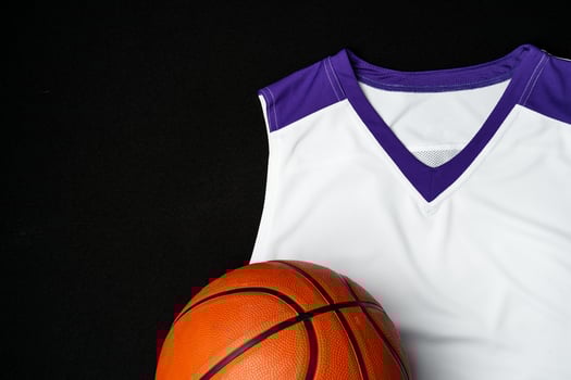 Close-Up of Basketball and White and Purple Jersey on a Black Background photo