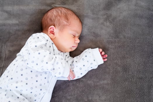 Close-up portrait of adorable baby boy sleeping in bed, 1 year old baby concept photo