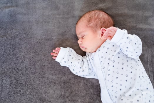 Peaceful baby lying on a bed while sleeping in a bright room. photo