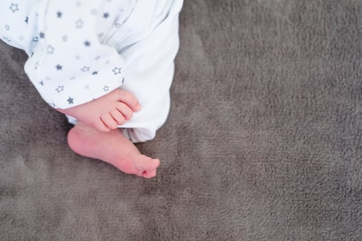 Newborn baby on a white blanket - tiny baby feet closeup photo