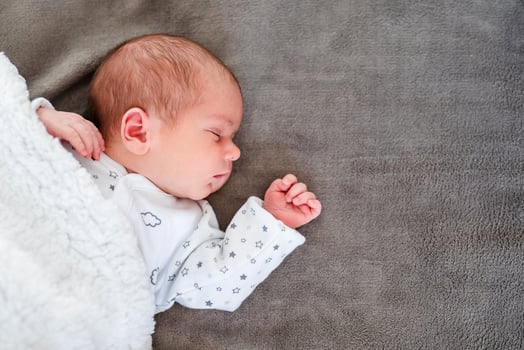 Close-up portrait of adorable baby boy sleeping in bed, 1 year old baby concept photo