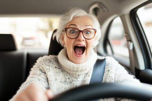 Senior woman with glasses smiles while driving a car photo