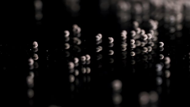 Close up of tiny gravel pile left on reflective black surface. Stock footage. Small stones at the laboratory during quality control of contruction materials process. photo
