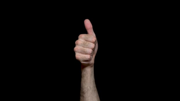 Male hand shows good job sign, thumbs up for agreement, success business concept. Isolated on black background, hand showing thumbs up, like, good, approval, acceptance, okay, positive hand gesture. photo