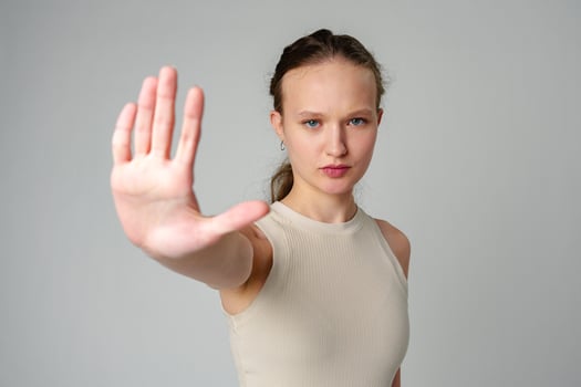 Young Woman Making Stop Sign With Hands on gray background photo