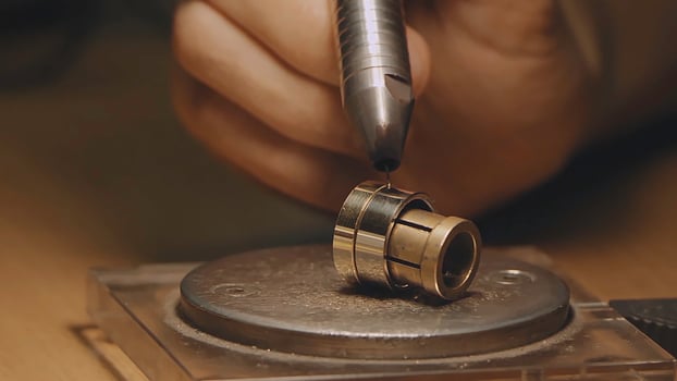 Production of rings. Jeweler working with wax model ring in his workshop. Craft jewelery making. Detail shot with low depth of field. Jeweler making handmade jewelry on vintage workbench. Craft of photo