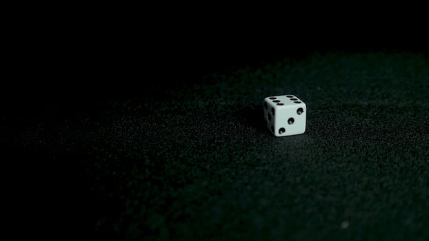 Female hand throwing dice on black background in slow motion. Two standard six-sided pipped dice with rounded corners on black background. photo