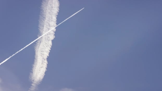 Large passenger supersonic plane flying high in clear blue sky, leaving long white trail. Airplane flying in white clouds in a blue sky. Airplane flying blue sky photo