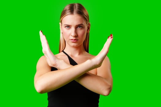 Young Woman Making Stop Sign Gesture on green background photo