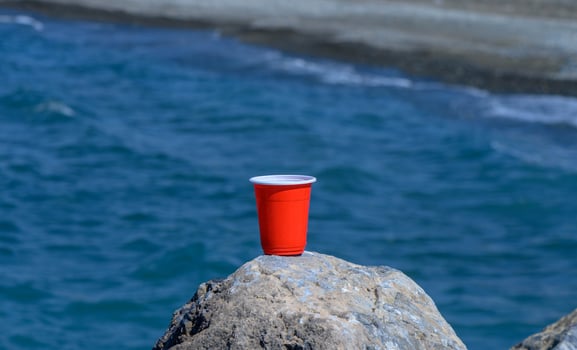 red plastic glass on the background of the sea and beach photo