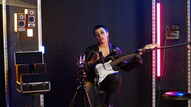Singing coach recording an online lesson for voice training in studio, vocal exercises on live stream tutorial. Musical instructor with a heavy metal vibe teaching the basics. Camera B. photo