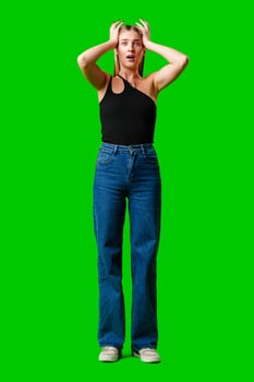 Young Woman Holding Hands Up to Head against green background photo