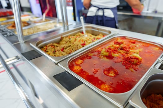 Bustling Cafeteria Serving Line During Lunchtime Offering a Variety of Dishes photo