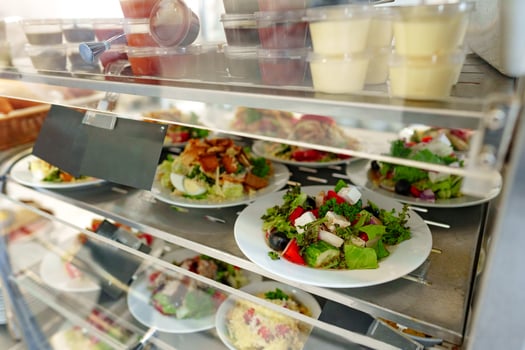 Freshly Prepared Salads on Display in a Cafeteria During Lunchtime photo