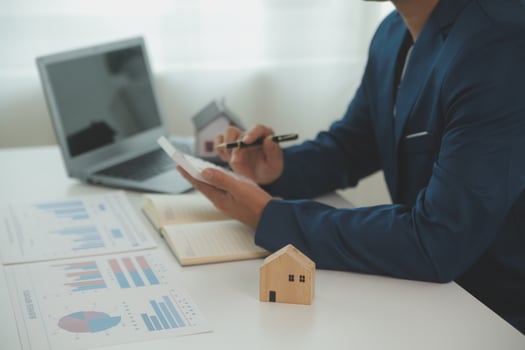 Businessmen holding pens, signing home titles with insurance, care about real estate services and the idea of real estate agents offering interest in installments to their customers. photo