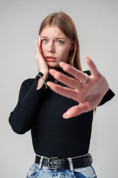 Young Woman Expressing Discomfort and Disapproval With Hands Up in Studio photo
