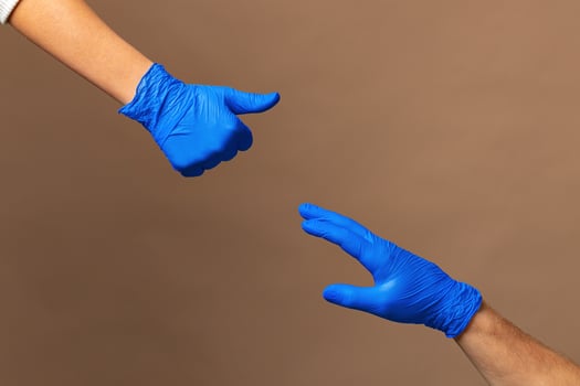 Male and female hands in medical gloves stretch to each other. Help concept. photo