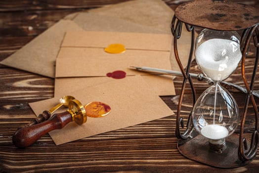 Wooden desk with vintage sandglass and old letter photo