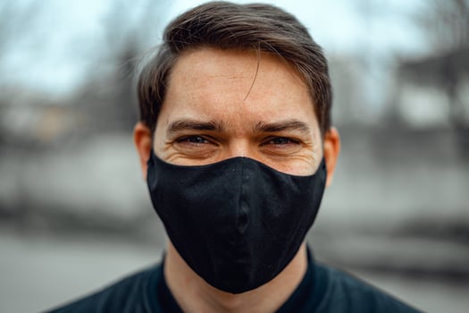 Portrait man in medical mask. Young man stands on light background and looking at camera. COVID-19 Pandemic Coronavirus. photo