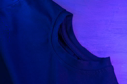 Black t-shirt in neon light close up on a table photo