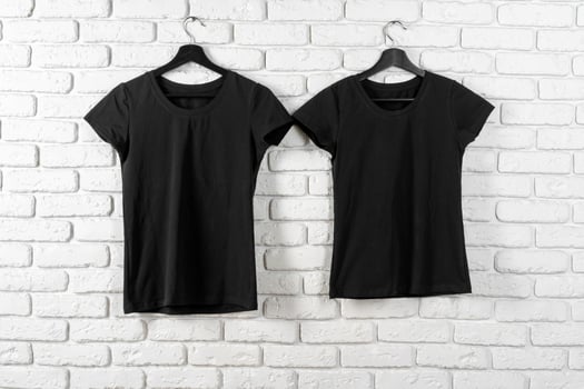Black t-shirt hanging on a hanger against brick wall photo
