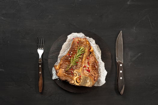 Top view of grilled t-bone steak on black table photo