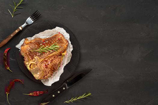Top view of grilled t-bone steak on black table photo