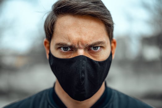 Portrait man in medical mask. Young man stands on light background and looking at camera. COVID-19 Pandemic Coronavirus. photo