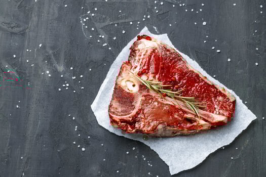 Raw fresh meat t-bone steak with spices on a dark background photo
