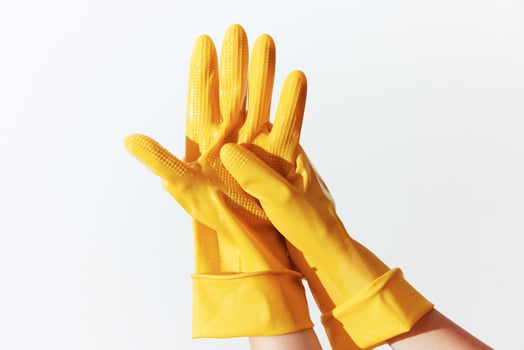 Woman's hand wearing yellow rubber gloves, isolated on white background. photo