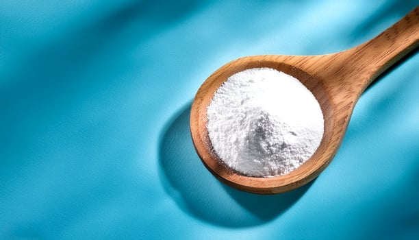 Baking soda in wooden spoon isolated on light blue background photo