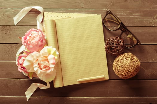 flowers and a notebook on wooden background photo