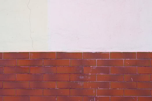 Half of the red brick wall is painted over with white plaster. Abstract construction background. photo
