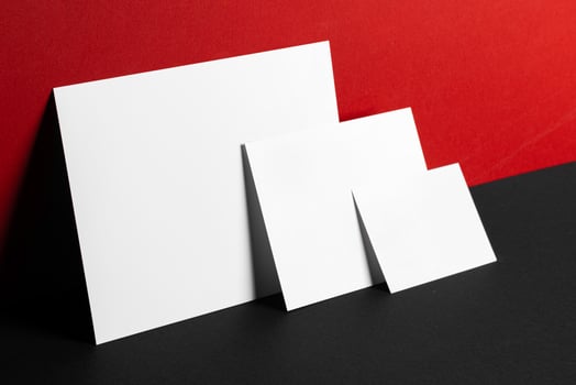 Blank white business cards on red and black paper background photo