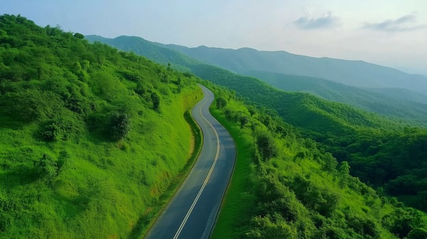 Asphalt road way in green forest mountain valley aerial view photo