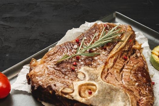 Top view of grilled t-bone steak on black table photo